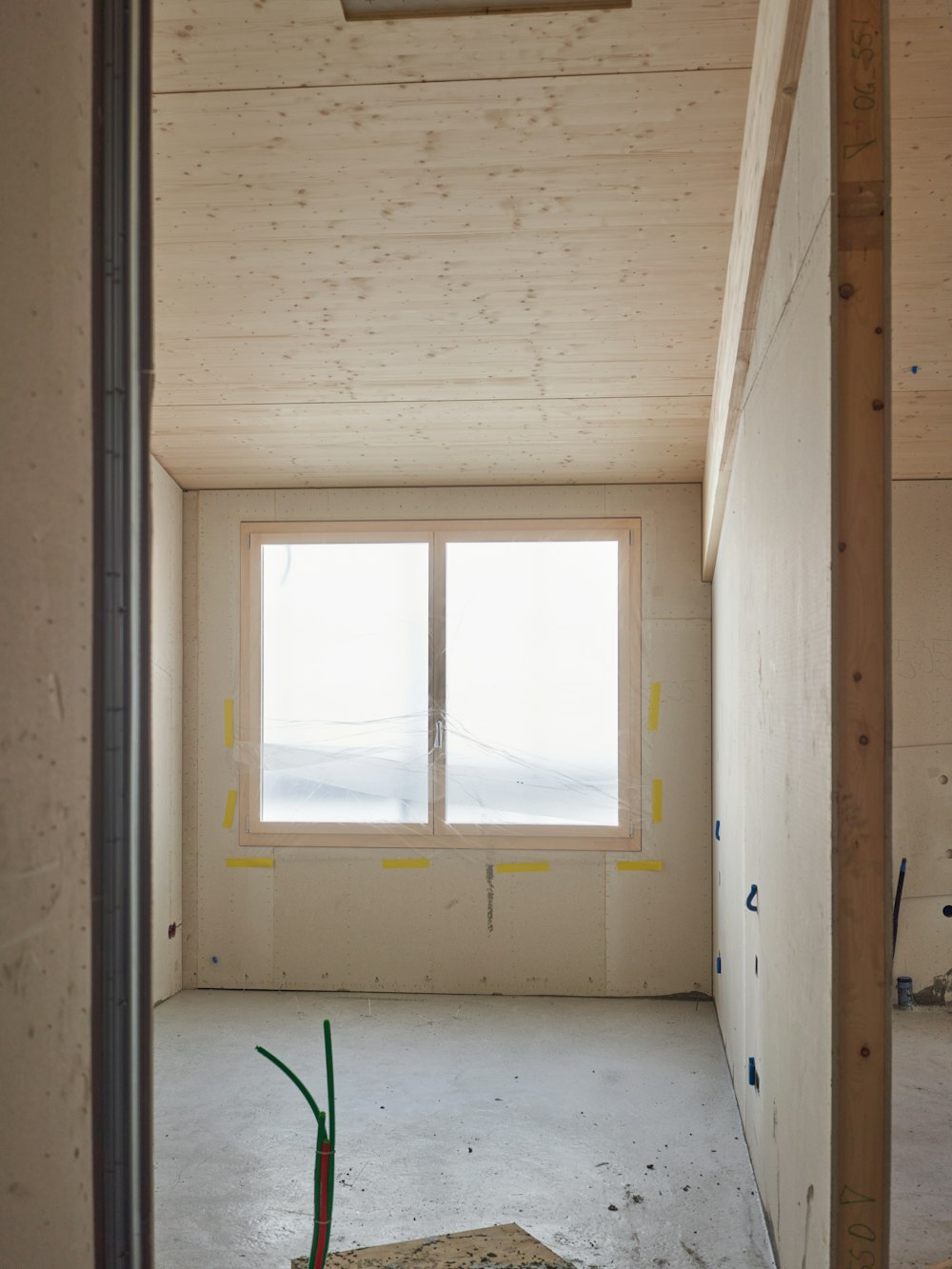 A gutted house interior with exposed wall studs lit by daylight